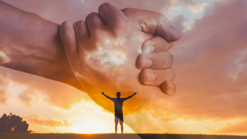 A person standing tall on a hilltop with arms open wide during sunrise, symbolizes standing firm in faith and hope in God’s presence.